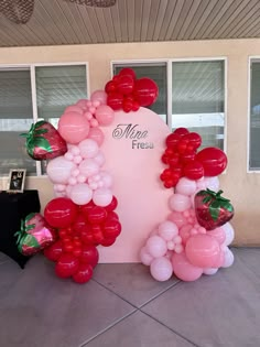 the balloon arch is decorated with strawberrys and balloons