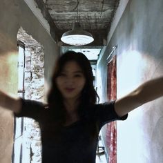 a woman standing in an alley way with her arms outstretched