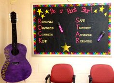 two chairs are in front of a blackboard with writing on it and purple guitar