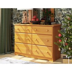 a wooden dresser sitting next to a christmas tree