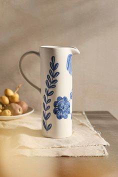 a blue and white pitcher sitting on top of a table next to other food items