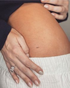 a close up of a person's belly with her hand on the side of her stomach