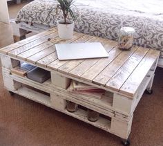 a coffee table made out of pallet wood with a laptop on top and some books