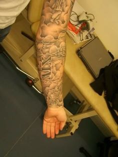 a man with tattoos on his arm and leg is standing in front of a computer desk