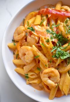 a white bowl filled with pasta and shrimp