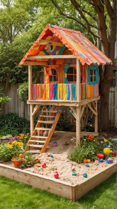 a wooden play house with colorful curtains on the roof and stairs leading up to it