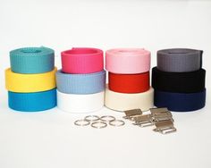 five different colored belts and two pairs of metal buckles on a white background with space for text