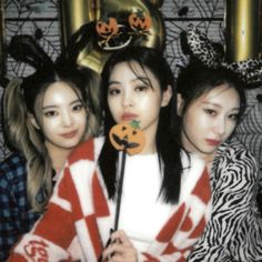 three young women posing for a photo with halloween decorations on their head and one holding a jack - o'- lantern