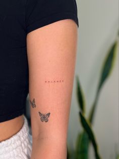 a woman's arm with butterflies on it and the word balance written in cursive writing