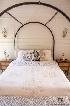 a white bed with a metal frame and headboard is shown in this bedroom setting