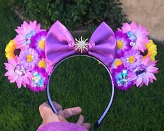 a person wearing a purple mouse ears with flowers on it