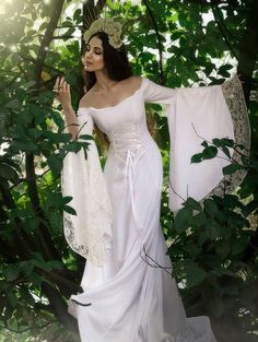 a woman dressed in white is posing for the camera