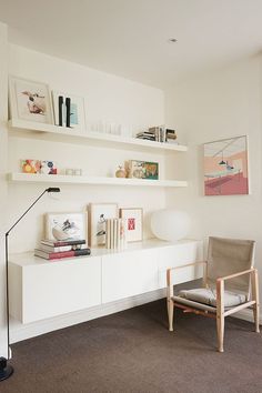 a living room filled with furniture and books on top of white shelving unit units