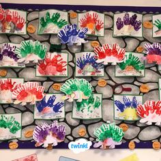 a bulletin board with handprints on it and colorful paper flowers in the middle