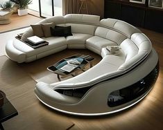 a large white couch sitting on top of a wooden floor next to a coffee table