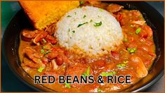 red beans and rice in a black bowl with bread on the side that says red beans and rice