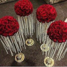 four vases with roses and crystal rods in them