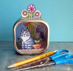 there is a tin with a cat on it and scissors next to it