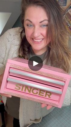 a woman holding up a pink radio with the word singer on it's side