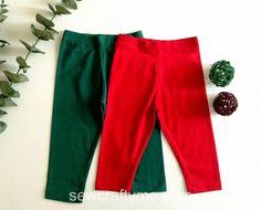 two red and green pants sitting next to each other on top of a white surface