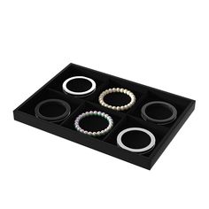 four bracelets in a black box on a white background