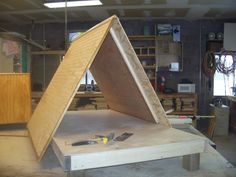 a large wooden object sitting on top of a table in a room filled with tools