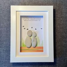 two rocks sitting on top of each other in a white frame with a quote above it