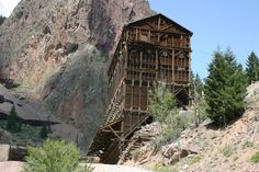 an old wooden structure on the side of a mountain