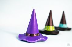 three small purple and green witches hats sitting on top of each other