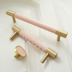 two pink and gold handles on a white door