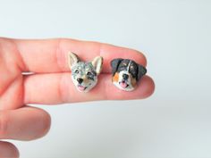 two miniature dogs sitting on top of each other in the palm of someone's hand