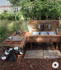 an outdoor table and bench made out of wooden pallets with pots and pans on them