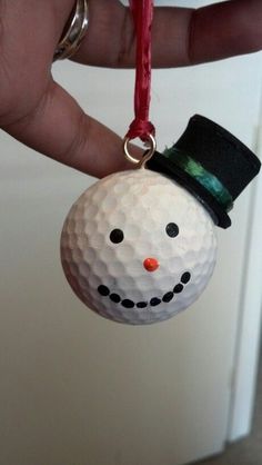 a golf ball ornament with a snowman face on it's head