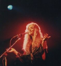 a woman standing in front of a microphone