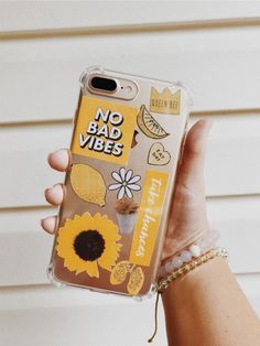 a person holding up a clear phone case with stickers on it that says, no bad vibes