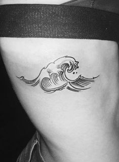 a black and white photo of a woman's stomach with waves tattoo on it