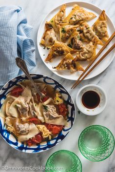 a plate of dumplings with chopsticks next to it on a marble table