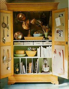 an open cabinet with pots and pans on it