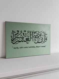 an arabic calligraphy is displayed on a shelf