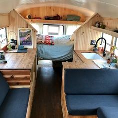 the interior of an rv with wood paneling and blue couches