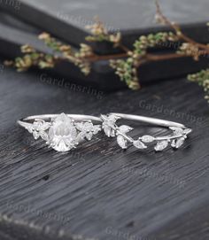 an image of a wedding ring on a wooden table with greenery in the background