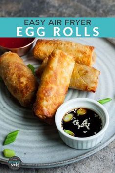 egg rolls on a plate with dipping sauce