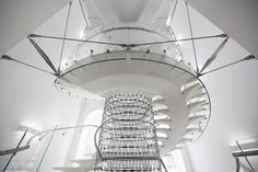 a spiral staircase in a building with glass railings