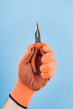 a hand holding a pair of scissors on top of a blue background with the sky in the background