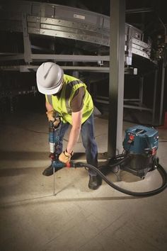 a man in yellow shirt and white hat using a power drill