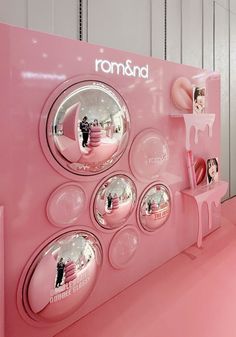 a pink display with round mirrors and photos on it