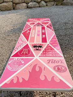 a pink and white surfboard sitting on the ground