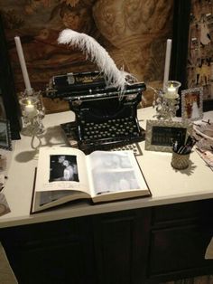 an old fashioned typewriter sitting on top of a table next to candles and pictures