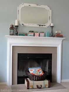 a white fireplace with a basket and mirror on top