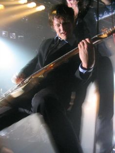 a man sitting on top of a chair holding a guitar